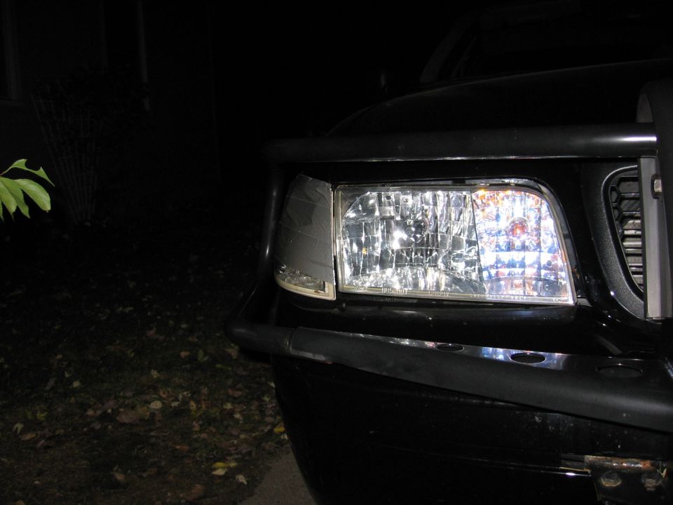Front corner of a black 2000 Ford Crown Victoria, showing the headlight and part of the grille. Bull bar is visible
