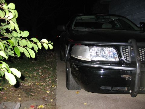 2000 Ford Crown Victoria - A black Ford Crown Victoria, equipped with a push bar, is parked outside at night.
