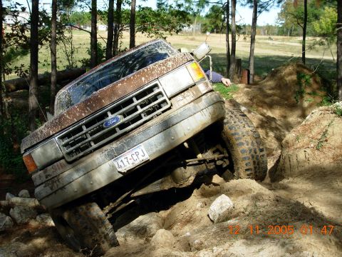 1987 Ford Bronco - This Ford truck is navigating a challenging off-road course with steep inclines and rough terrain.