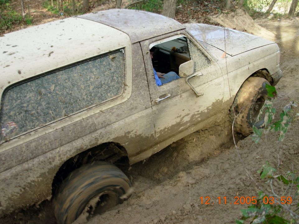 1987 Ford Bronco stuck in mud on an off-road trail