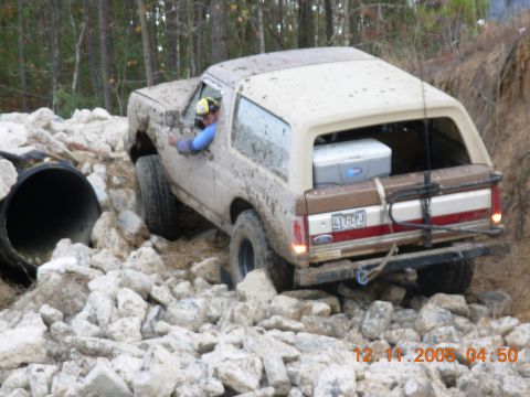 1987 Ford Bronco - A 1987 Ford Bronco is shown maneuvering through a challenging rocky terrain during an off-road excursion.