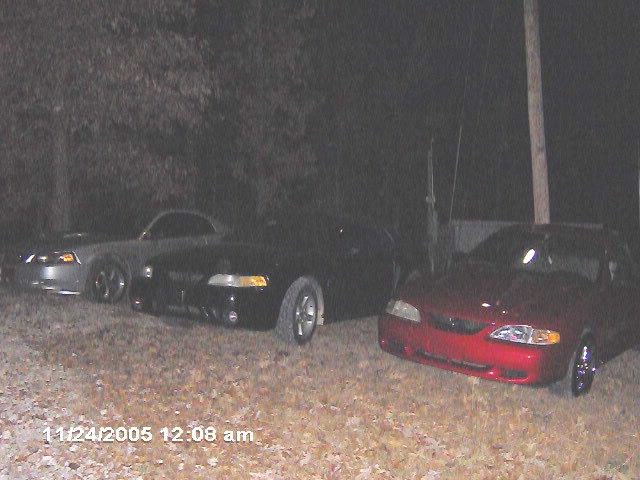 Red 1996 Ford Mustang front view, parked with two other Mustangs