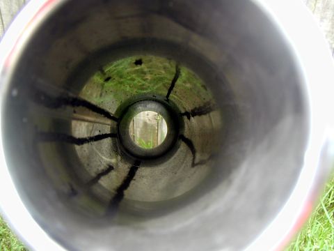 2000 Ford Crown Victoria - View from inside a vehicle's exhaust pipe shows carbon buildup and an outdoor scene.