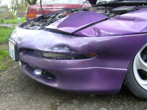 1997 Ford Probe - Front view of a damaged purple 1997 Ford Probe, with another vehicle visible in the background.