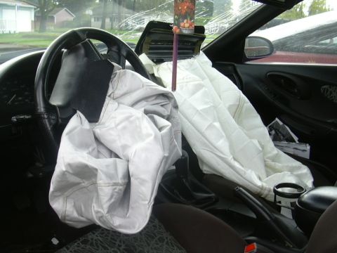 1997 Ford Probe - The interior of a car shows deployed airbags and a cracked windshield, indicating a recent collision.