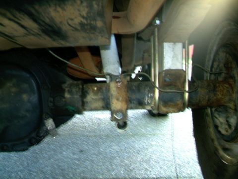1987 Ford Bronco II - Close-up view of a vehicle's rear axle suspension components, including the shock mount and U-bolts.