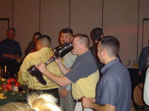 1996 Ford Probe - A man is seen drinking from a large novelty champagne glass at an event.