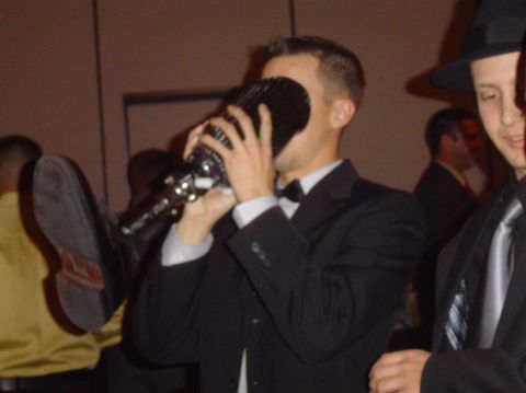 1996 Ford Probe - A man in formal wear holds a large microphone, possibly at an event.