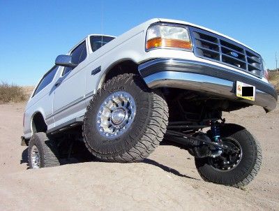 1995 Ford Bronco - This lifted 1995 Ford Bronco is shown off-road with its front wheel elevated.