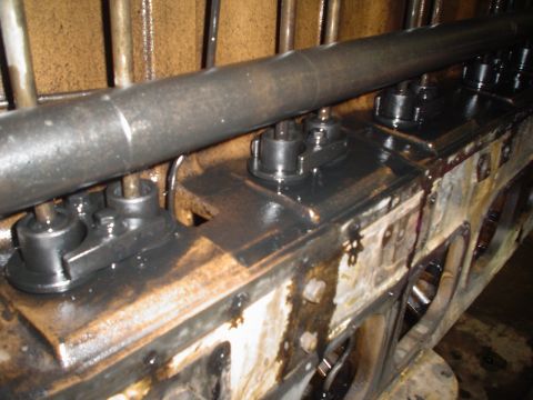 1966 International School Bus - Close-up view of an engine block's internal components, showing pushrods and rocker arms coated in oil.