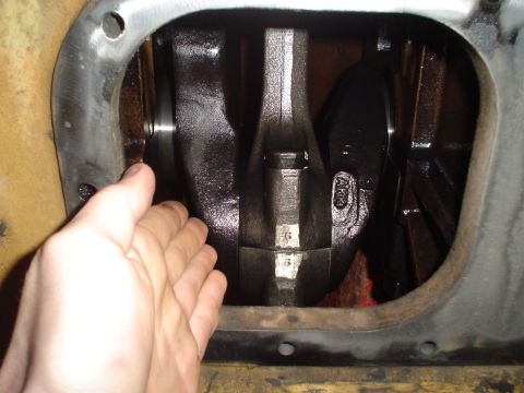 1966 International School Bus - Engine crankshaft and connecting rods shown with a hand for scale; numbers are visible on the rods.