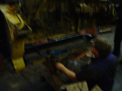 1966 International School Bus - A person is working on a large engine part in a workshop setting.