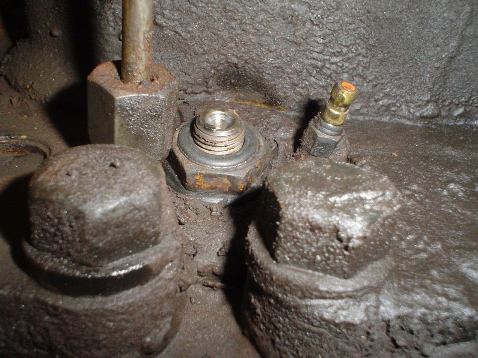 Close-up of engine components with nuts and a brass fitting