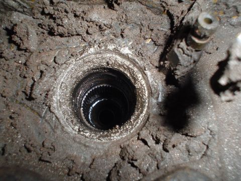 1966 International School Bus - Detail of a splined shaft opening, covered in dirt and grime, likely a component from a vehicle's drivetrain.