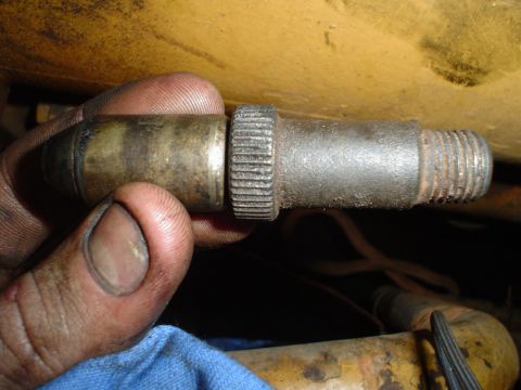 1966 International School Bus - A close-up shows a person holding a metal component with a threaded end and knurled grip.