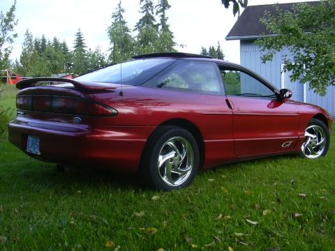 1997 Ford Probe - A red 1997 Ford Probe GT is shown from a three-quarter front angle, parked on a grassy lawn.