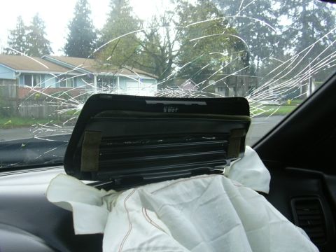1997 Ford Probe - Interior view of a 1997 Ford Probe showing a deployed airbag and a severely cracked windshield.