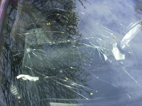 1997 Ford Probe - The vehicle's windshield is severely damaged with numerous cracks radiating from impact points.