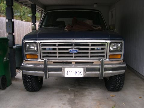1986 Ford Bronco - This blue Ford Bronco features a distinctive grille and front end, captured from a straight-on perspective.
