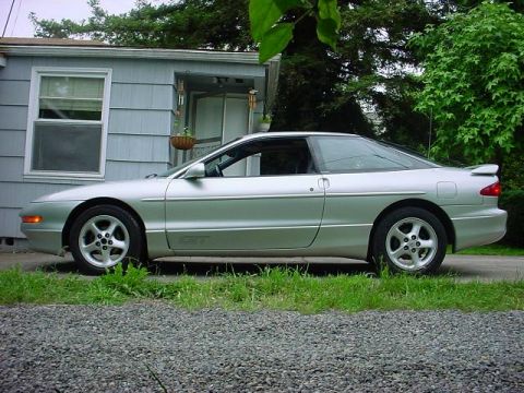 1994 Ford Probe - This silver 1994 Ford Probe coupe is seen from the side, parked in front of a house.