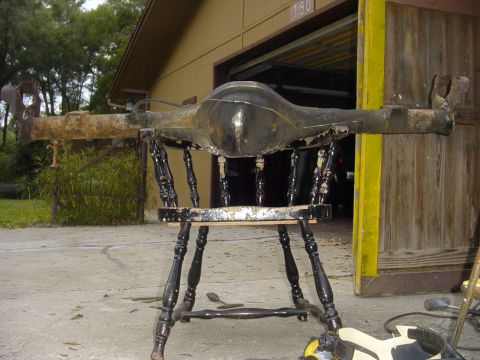 1989 Ford Bronco - A rear axle assembly is displayed on a chair outside a garage.