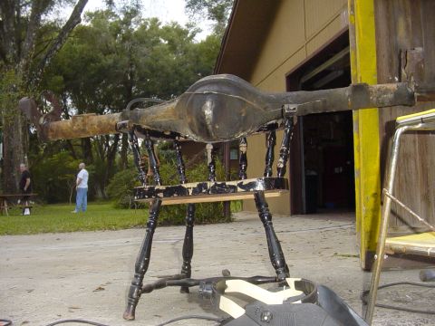 1989 Ford Bronco - A rear axle assembly is displayed on a chair outdoors, with a Supermotors.net watermark at the bottom right.