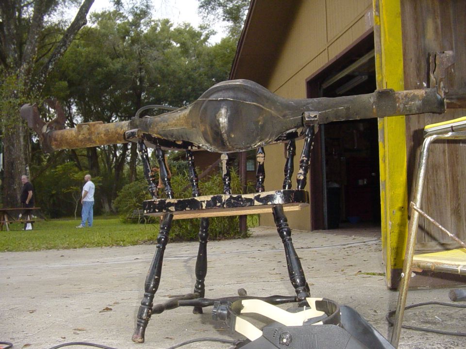 Rear axle assembly on a chair, Supermotors.net logo visible