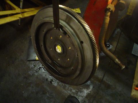 1966 International School Bus - Close-up of a flywheel with its ring gear, likely removed from an engine for service.