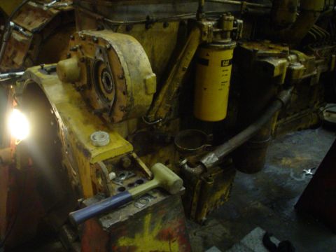 1966 International School Bus - A close-up view of a yellow engine component, likely part of a larger machine, with a CAT filter visible.