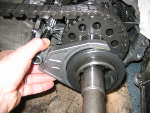 1992 Ford Bronco - Close-up of a disassembled transfer case or transmission showing a hand holding an internal component near a planetary-style gear, drive ch…