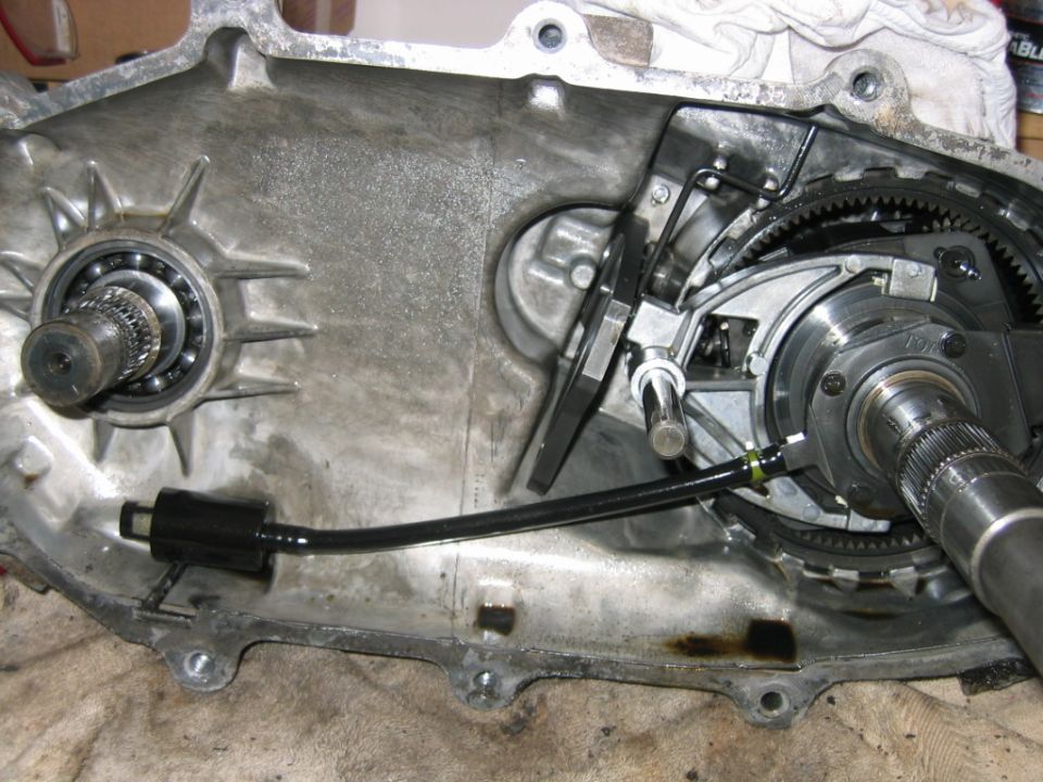 Opened aluminum transfer case showing gears, bearings, splined shaft and shift fork