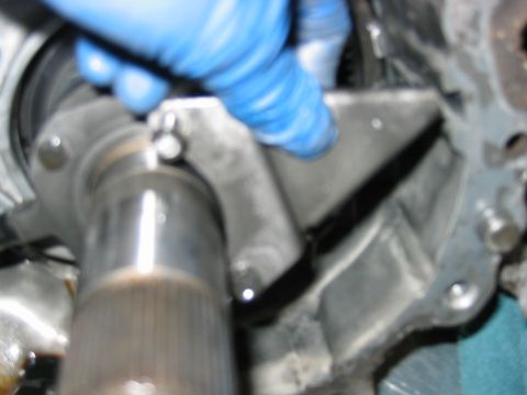 1992 Ford Bronco - Close-up of a mechanical assembly showing a splined shaft and metal housing, with a blue-gloved hand working near the components. Grease an…