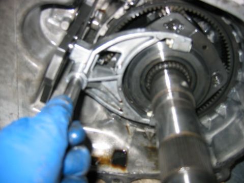 1992 Ford Bronco - Close-up inside an opened transmission case during teardown, showing a large splined output shaft, ring-gear teeth, and a cast internal lev…