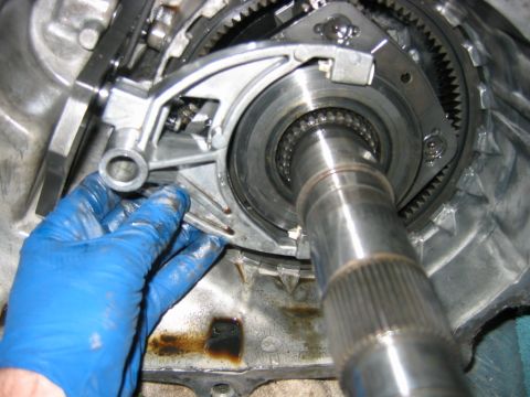 1992 Ford Bronco - Close-up inside an opened automatic transmission case during a rebuild, with a splined output shaft protruding through the geartrain and a…