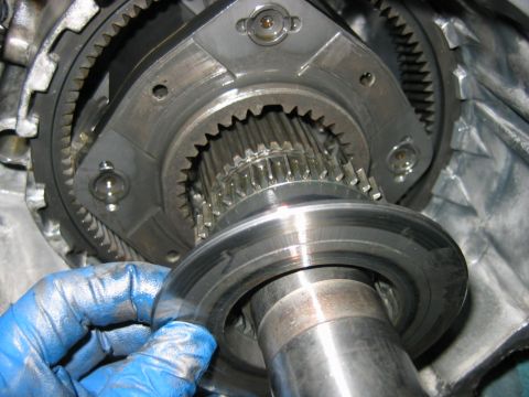 1992 Ford Bronco - Macro shot inside a partially disassembled transmission or transfer case, showing a splined output shaft, surrounding ring-gear teeth, and…