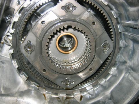 1992 Ford Bronco - Close-up of an automatic transmission's internal planetary gearset, showing the ring gear, planet gears, and a bronze-colored bushing/thrus…