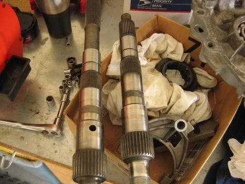1992 Ford Bronco - Two splined transmission output/input shafts laid side by side on a workbench, resting on a shop rag inside a USPS Priority Mail box. Nearb…