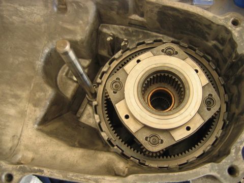 1992 Ford Bronco - Close-up of an automatic transmission's internal components, showing a planetary gear set with a ring gear, sun gear splines, clutch pack,…