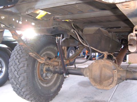1985 Ford Ranger - The rear suspension and drivetrain components of a truck are shown from underneath, with another vehicle in the background.