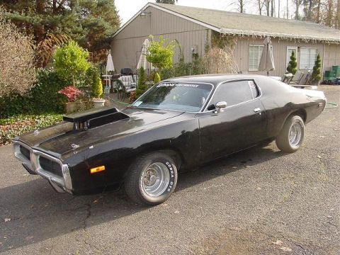 1993 Ford Bronco - This black 1973 Dodge Charger SE features a prominent hood scoop and classic chrome wheels.