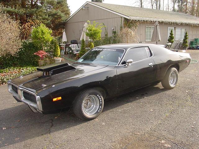 Black 1973 Dodge Charger SE with hood scoop and chrome wheels