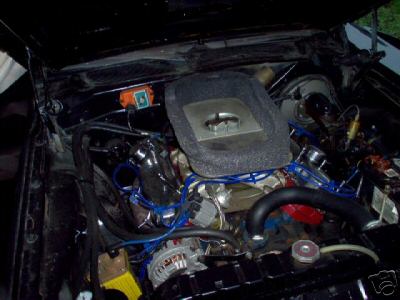 1993 Ford Bronco - The engine bay of a vehicle is shown with various components and blue wiring visible.