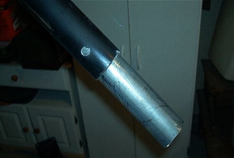 1986 Ford Bronco - Close-up view of joined metal tubing, likely part of a roll cage, with a visible bolt and cabinet background.