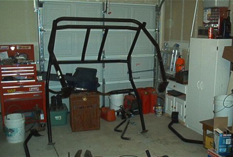 1986 Ford Bronco - Roll cage components are laid out in a garage setting, awaiting installation.