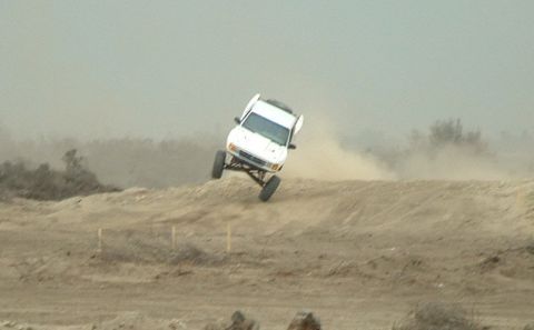 1984 Ford Bronco - This vehicle is airborne while traversing a dusty, off-road terrain.