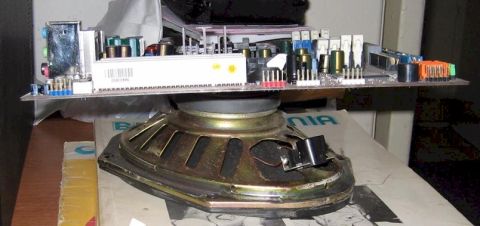 2001 Ford Taurus - This image shows a circuit board precariously balanced on top of a speaker, with no visible vehicle components.