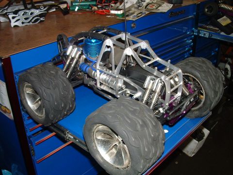 1994 Ford Bronco - RC monster truck sits on a blue tool chest, with a flame-decaled body shell nearby.