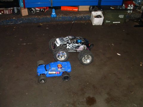 1994 Ford Bronco - Two remote control monster trucks are parked on a garage floor.