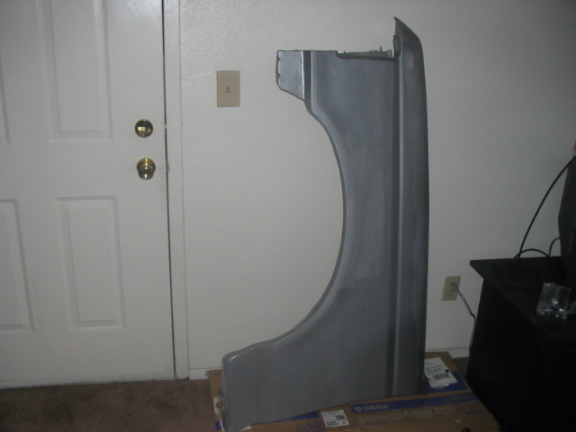 Gray car fender leaning against a wall