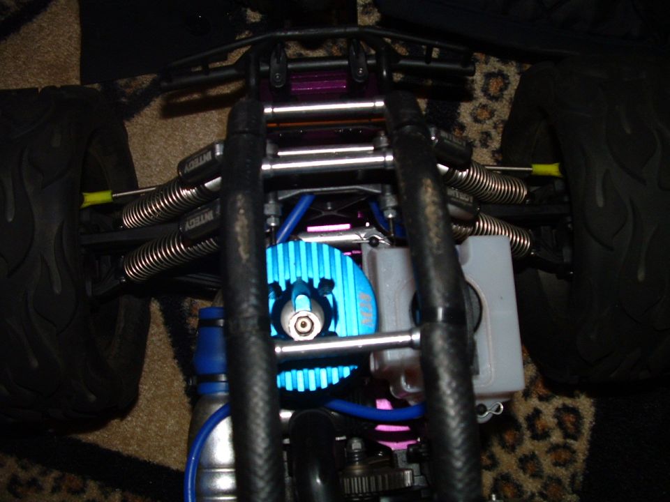 Remote control car chassis with blue motor, silver springs, and black tires